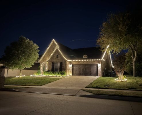 Brick home with C9 Christmas lights outlining the gables and roofline