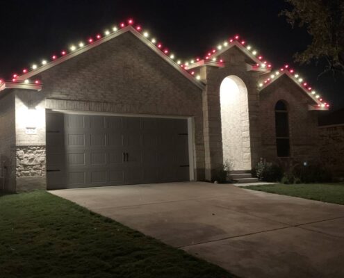 Single-story home with red and white roofline Christmas lights